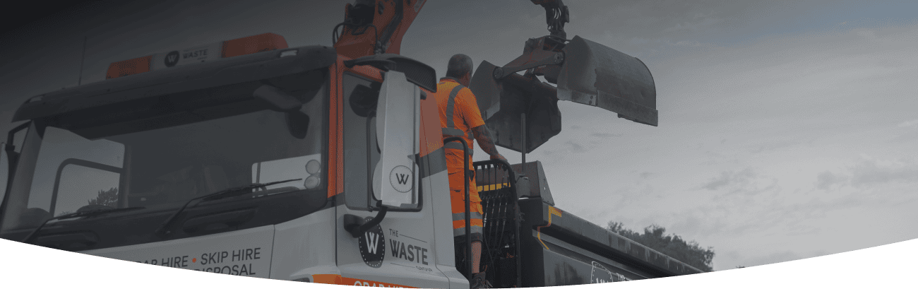 waste group employee standing on a grab lorry