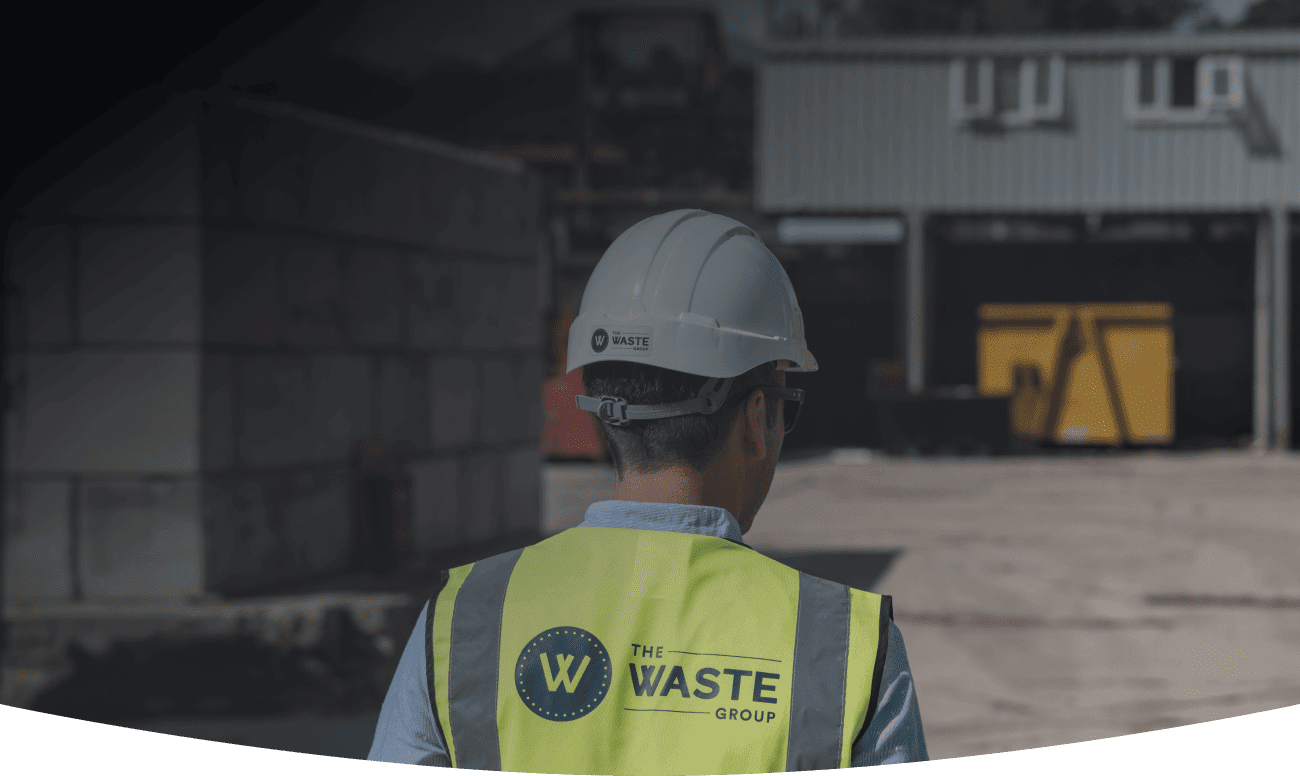a man wearing a vest with the waste group logo on his back