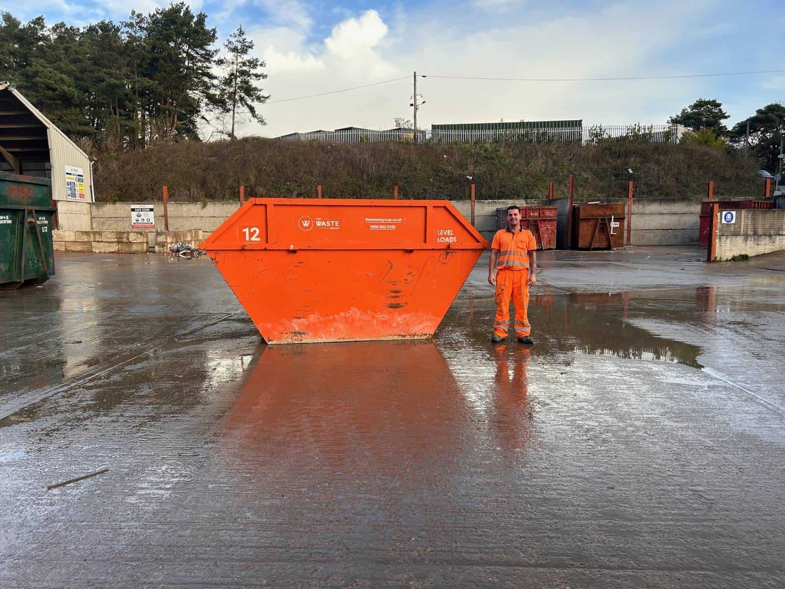 12 yard skip with a person standing beside it for scale at The Waste Group